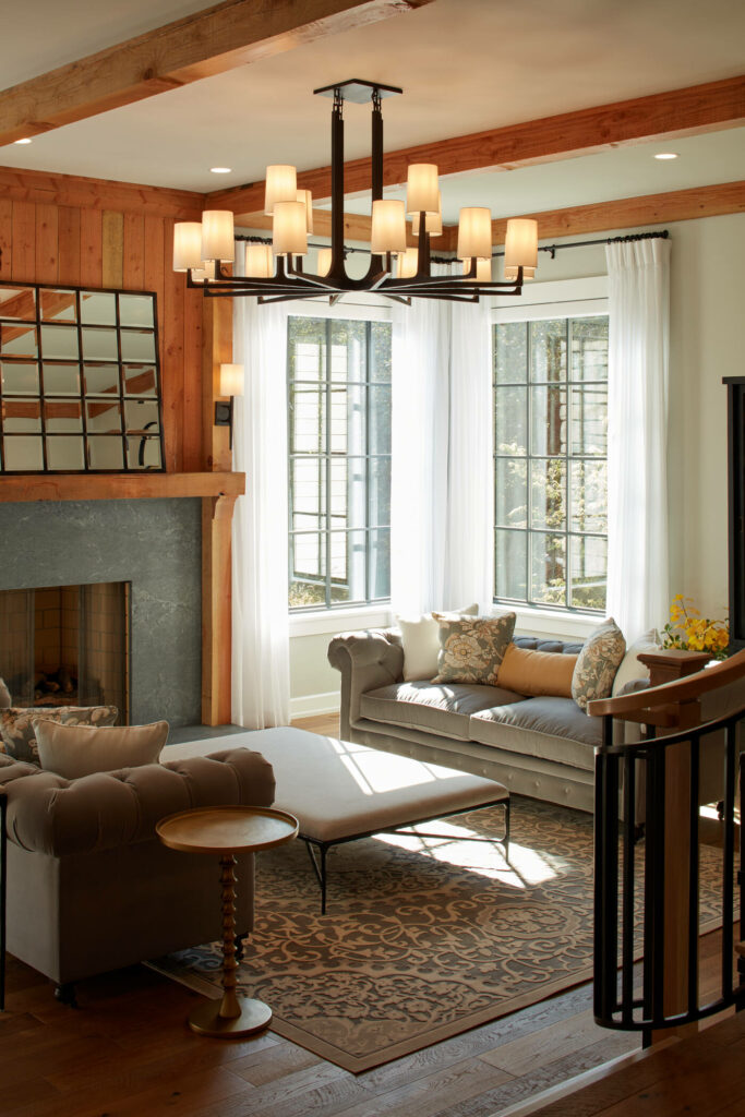 A cozy living room with a fireplace and wood beam ceilings. Built and designed by Curt Hofer custom homes and renovations.