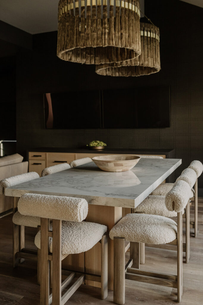 Dining area with modern furniture, artistic lighting, and a dark wall color in a custom home addition in Omaha, Nebraska, built by Curt Hofer.